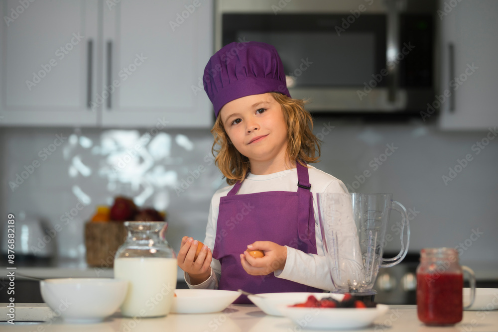 Child in chef hat and apron preparing in the kitchen. Child in chef hat and apron preparing in the kitchen.