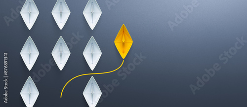Fototapeta Naklejka Na Ścianę i Meble -  Group of white paper ships in one direction and one yellow paper ship pointing in different way. Business for innovative solution concept. copy space