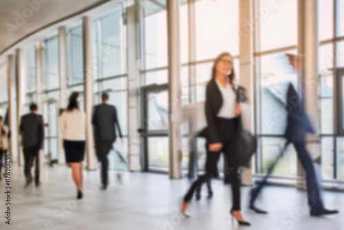 business people walking in the corridor of an business center, pronounced motion blur, crowded bright modern light office movement defocused. office background busy. talking and rushing in the lobby. 