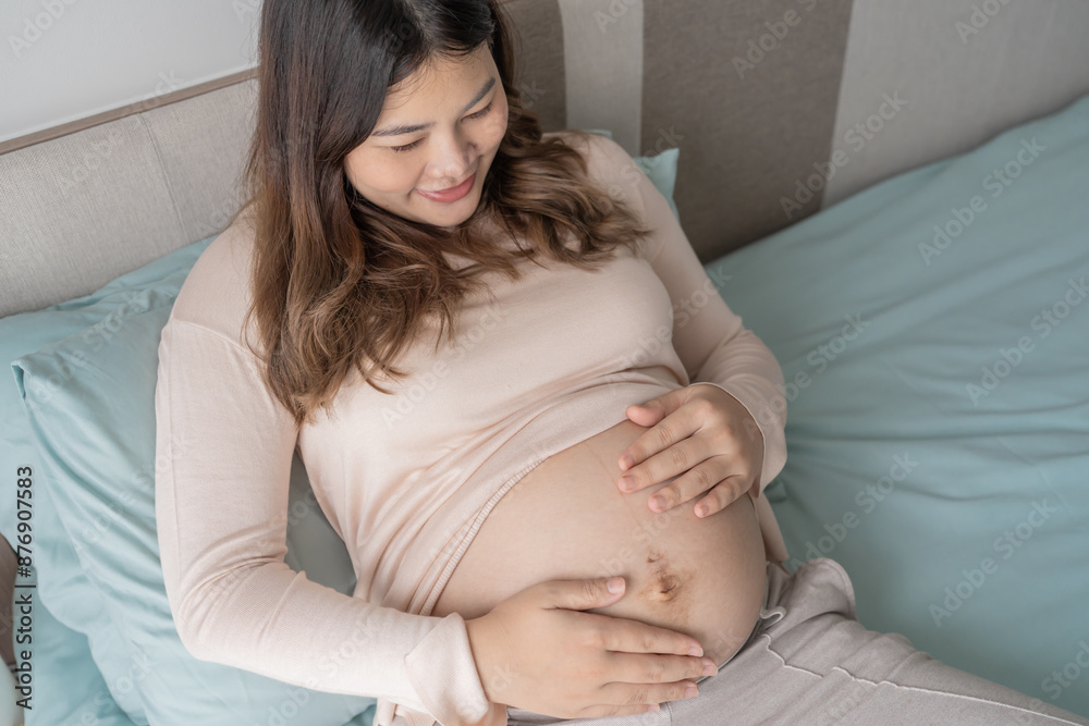 Pregnant asian woman holds hands on belly touching her baby caring about her health Beautiful happy pregnant woman tender mood photo of pregnancy Pregnant asian woman holds hands on belly touching her baby caring about her health Beautiful happy pregnant woman tender mood photo of pregnancy