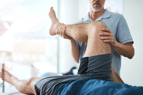 Medical, leg and physiotherapist with man patient in clinic for healing, rehabilitation or treatment. Physical therapy, stretch and healthcare worker with athlete for knee injury or accident recovery