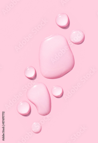 round drops of transparent gel serum on pink background