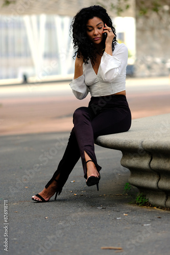 business woman resting on a bench and pacing while talking on the phone about work issues