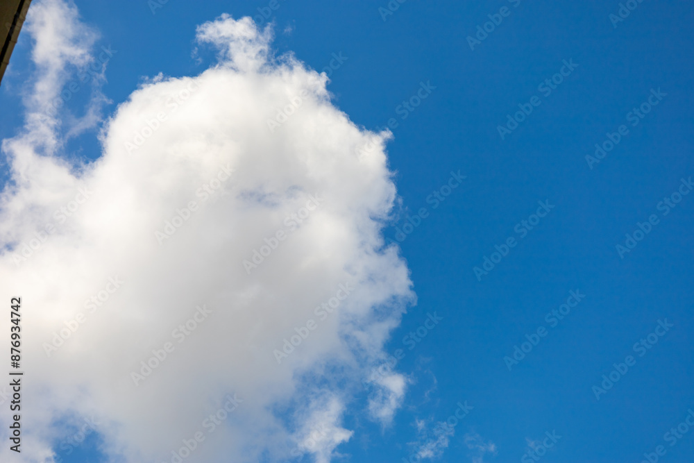 Obraz premium Fluffy White Cloud Against Clear Blue Sky