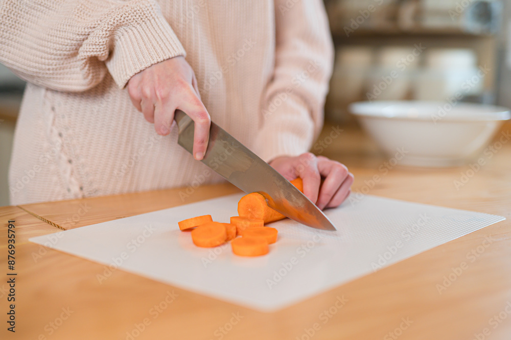 Girl cutting carrot on white cutting board with cut pieces of carrot Girl cutting carrot on white cutting board with cut pieces of carrot
