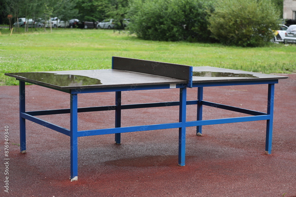 The yard tennis table is wet after the rain The yard tennis table is wet after the rain