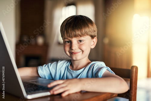 Portrait, boy and laptop with help for homework, study and online for preschool, e learning and growth. Happy kid, tech and educational games in home for language, math or skill for child development