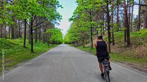 Wallpaper Mural Man Riding Bike Through The Park Between Tall Trees - Tracking Shot Torontodigital.ca