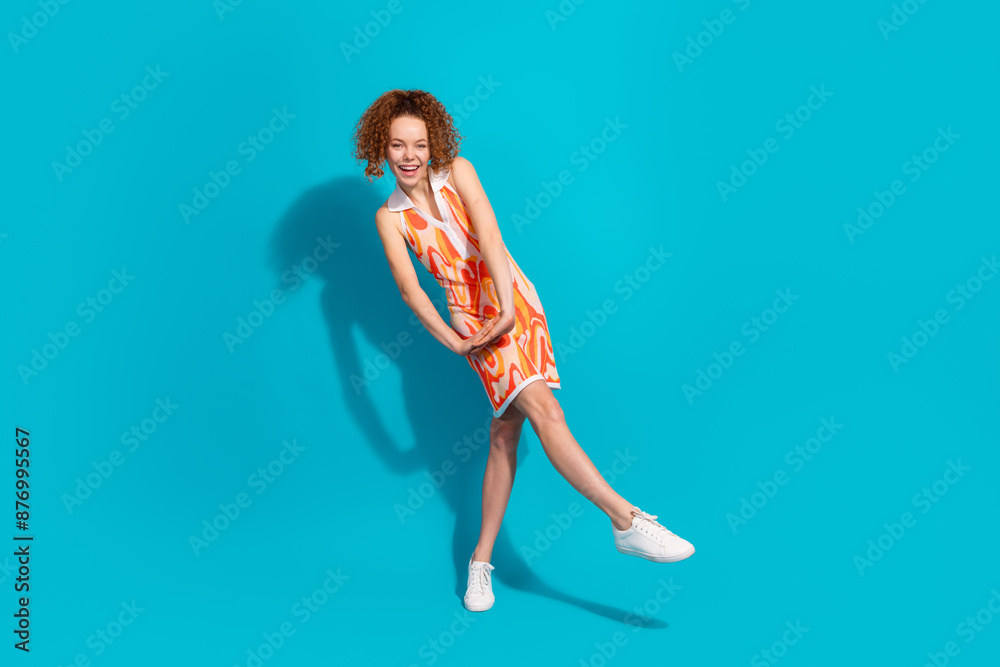 Full size photo of pretty young girl girlish dancing wear trendy orange outfit isolated on aquamarine color background Full size photo of pretty young girl girlish dancing wear trendy orange outfit isolated on aquamarine color background
