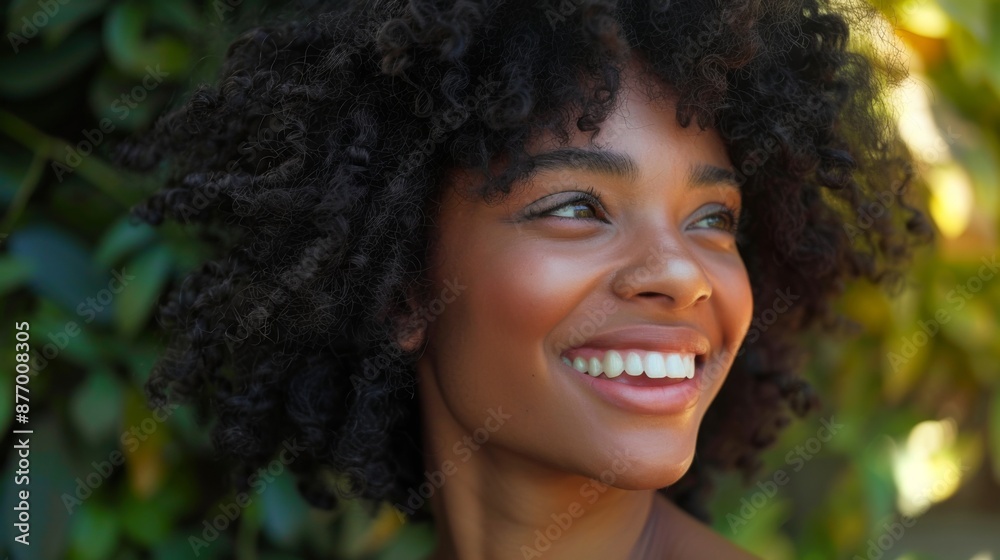 A woman with thick, curly hair smiling happily, her curls perfectly defined. A woman with thick, curly hair smiling happily, her curls perfectly defined.