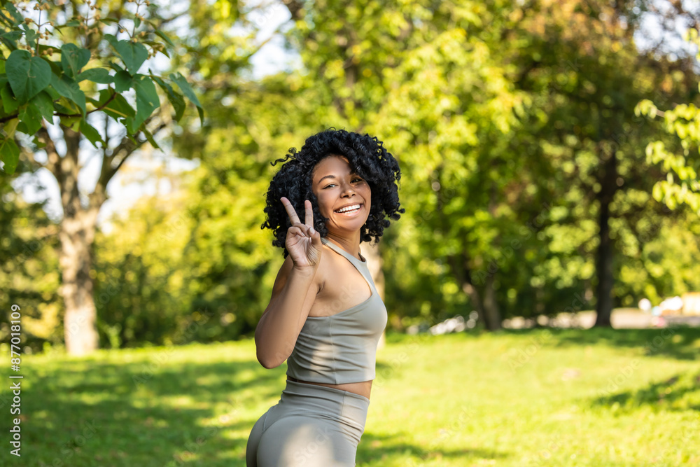Pretty curly-haired woman in the park having a workout and looking happy Pretty curly-haired woman in the park having a workout and looking happy
