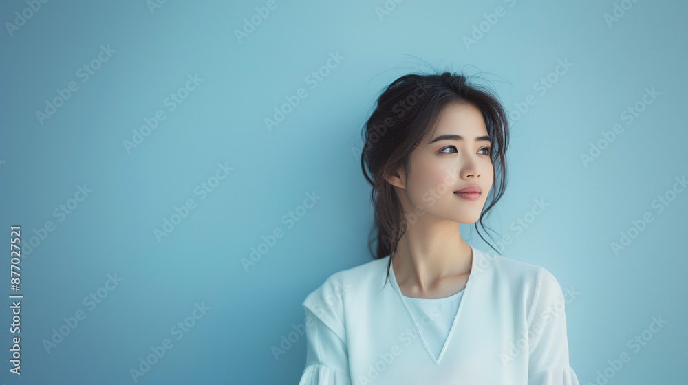 A beautiful Chinese woman dressed in a traditional outfit, standing gracefully against a soft blue background, exuding elegance and serenity. A beautiful Chinese woman dressed in a traditional outfit, standing gracefully against a soft blue background, exuding elegance and serenity.
