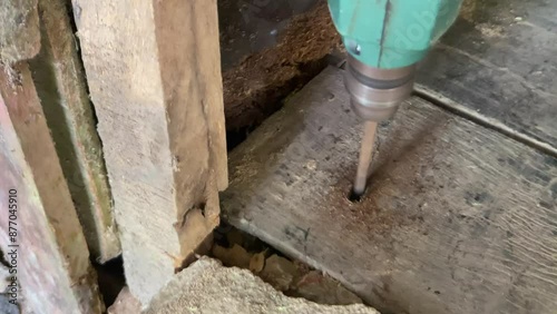 Wallpaper Mural Manual workers drill holes in wooden beams outdoors. Drill wooden board with machine Torontodigital.ca