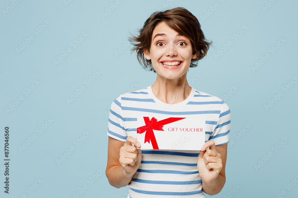 Young surprised fun woman wear striped t-shirt casual clothes hold gift certificate coupon voucher card for store isolated on plain pastel light blue cyan background studio portrait Lifestyle concept Young surprised fun woman wear striped t-shirt casual clothes hold gift certificate coupon voucher card for store isolated on plain pastel light blue cyan background studio portrait Lifestyle concept