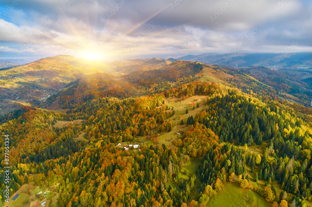 Aerial view of mountains at sunrise in autumn in Ukraine. Colorful landscape with mountain road, forest, houses on the hills, sunlight, sky in fall. Aerial view of mountains at sunrise in autumn in Ukraine. Colorful landscape with mountain road, forest, houses on the hills, sunlight, sky in fall.