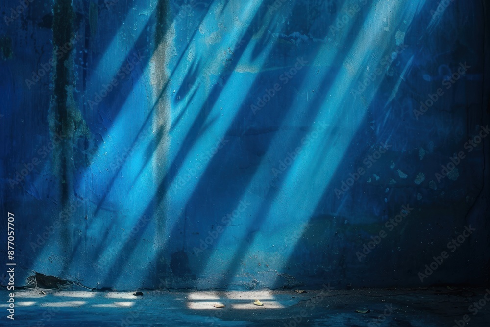 Fototapeta premium Light in the dark. Rays light on blue wall with smoke and shadow