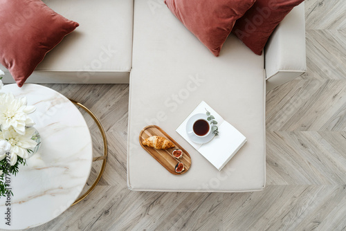 Flat lay view on sofa next to marble side table in living room at apartment