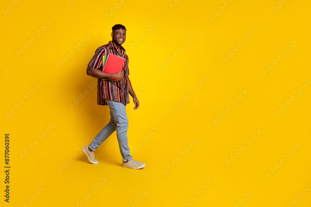Fototapeta premium Full body profile portrait of nice young man walk empty space wear shirt isolated on yellow color background