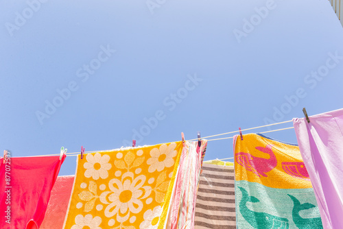 Colourful towels and swimmers hanging on washing line