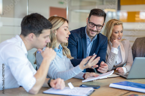 Planning and collaborating. Diverse team meets in office conference room discussing a project.