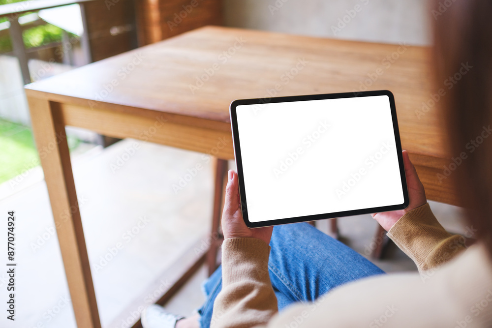 Mockup image of a woman holding digital tablet with blank white desktop screen