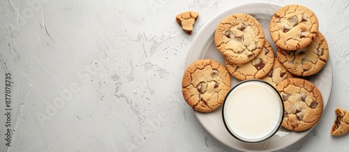 A delicious snack of cookies and milk presented on a rustic white background in a clear glass, ideal for showcasing with copy space image in a flat lay. photo