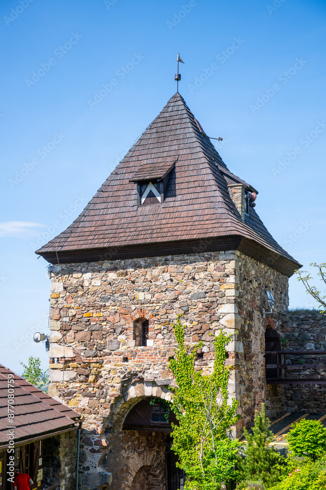 Fototapeta premium A view of the gate tower at Potstejn Castle Ruins in Czechia, with its stone walls, wooden roof, and a small window.