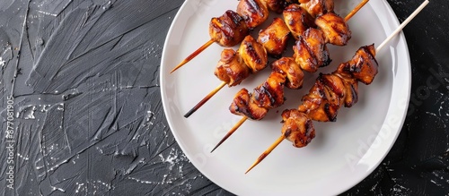 YAKITORI-style grilled chicken skewers featuring gizzards on a white plate with a copy space image. photo