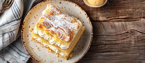 Top view of a portion of a classic Napoleon cake showcasing layers of puff pastry and custard, a traditional Russian dessert with copy space for adding text or images. photo
