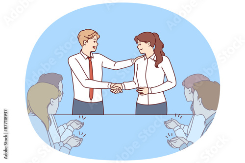 Handshake of boss and new employee of company during business meeting with colleagues. Man boss shakes hands with employee who has successfully completed complex project or attracted most customers