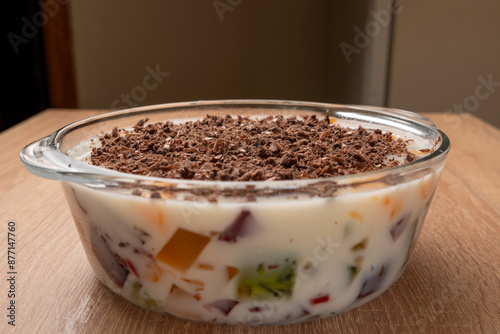 Chocolate shavings are added to the hardened dessert jelly. Preparation of gelatin desserts. photo