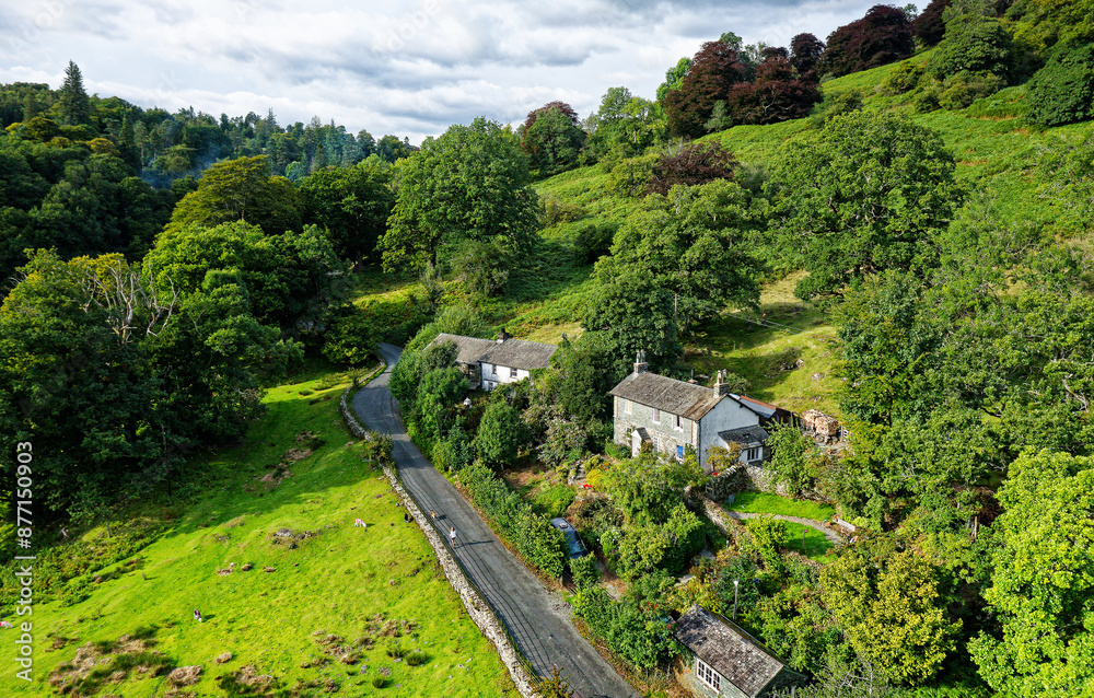 Lake District National Park landscape with rural road and cottage near Loughrigg Tarn, Langdale, in the central Lakes between Ambleside and Grasmere
