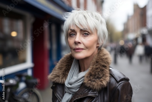 Portrait of mature woman with short hair in fur coat on city street