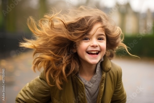 Portrait of a smiling little girl with her hair in the wind