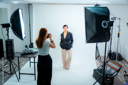 Beautiful young model in photo studio with photographer and makeup artist