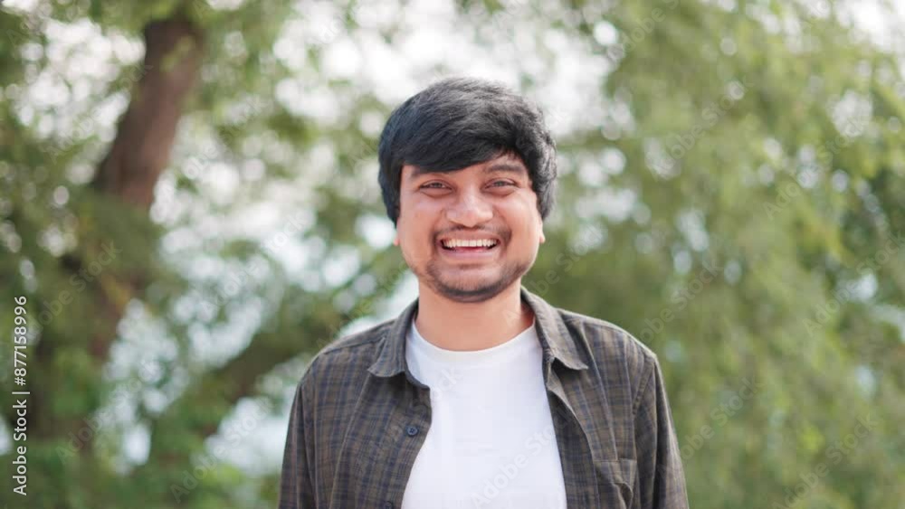4K shot of an Indian man with a positive attitude smiling while looking at the camera while standing outdoors. Happy young Indian man smiles at the camera. Positive feedback background with copy space 4K shot of an Indian man with a positive attitude smiling while looking at the camera while standing outdoors. Happy young Indian man smiles at the camera. Positive feedback background with copy space