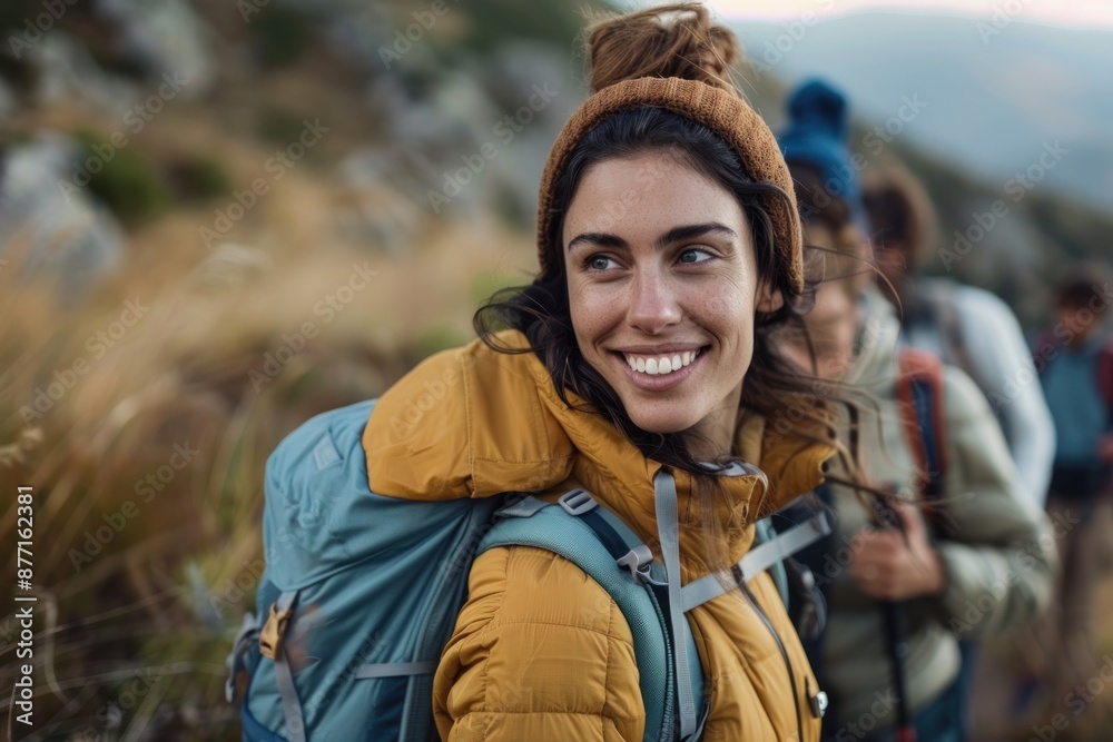 Smiling woman with backpack hiking in mountains, accompanied by friends, evoking adventure