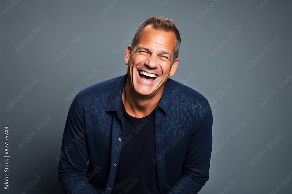 Handsome middle age man laughing. Studio shot over grey background. Handsome middle age man laughing. Studio shot over grey background.