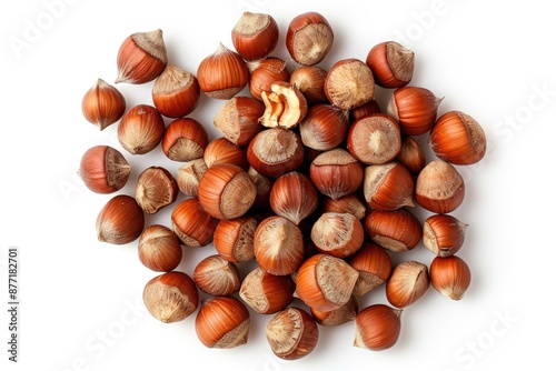 A pile of hazel nuts on a white surface, suitable for use in food or nature-related contexts