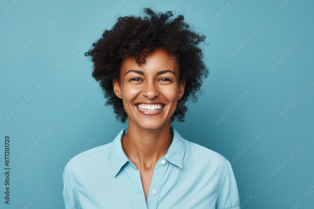 Smiling african american woman with afro hairstyle on blue background Smiling african american woman with afro hairstyle on blue background