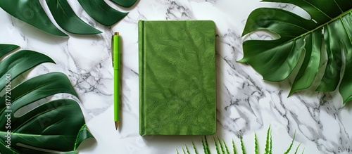 A green notebook and pen on...