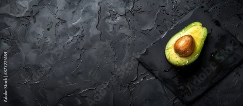 Half an avocado on a black ...