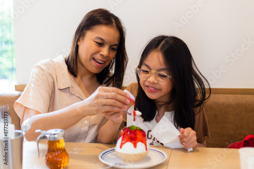 couple family came together in a cafe. Mom,  little daughter eat cakes and ice cream. They are happy together. Happy family lunch concept.