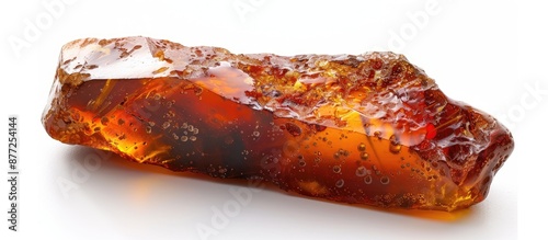 Elongated untreated amber with a crust displaying natural red brown hues on a white background creating a distinct copy space image photo