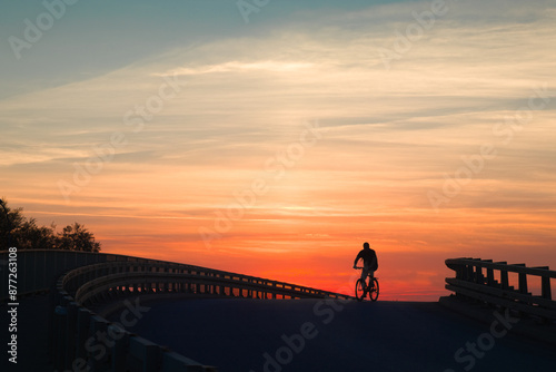 silhouette of a cyclist on a bridge