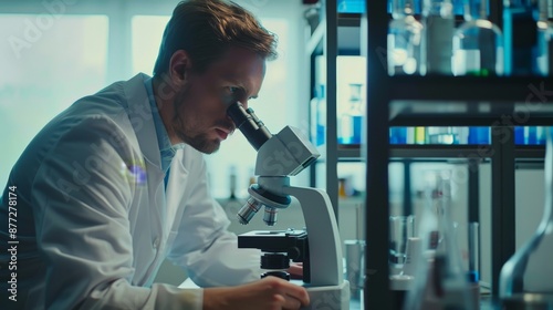 A scientist in a white coat looks through a microscope in a scientific laboratory. photo