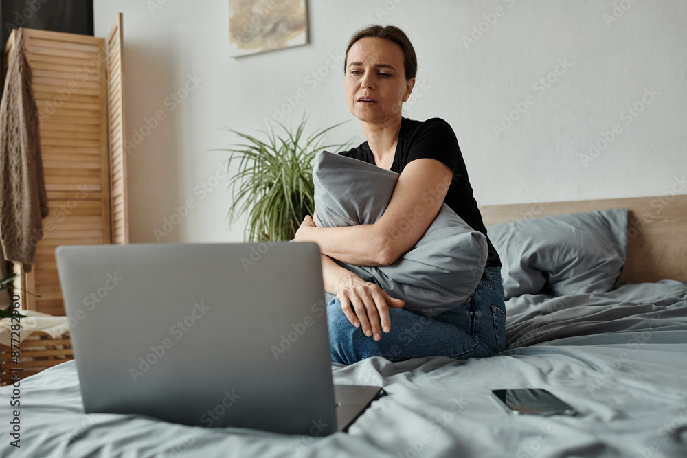 Middle-aged woman finds solace in therapy session on laptop. Middle-aged woman finds solace in therapy session on laptop.