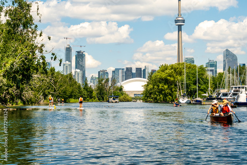 paddling on a channel  in the toronto islands in summer with the city skyline and white clouds in the background, room for text