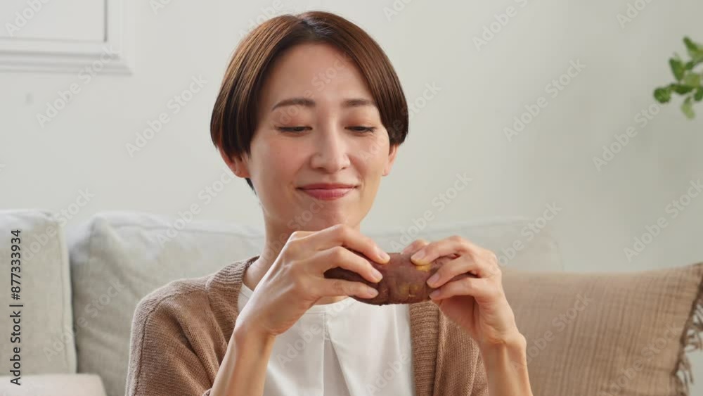 自宅で焼き芋を食べる女性