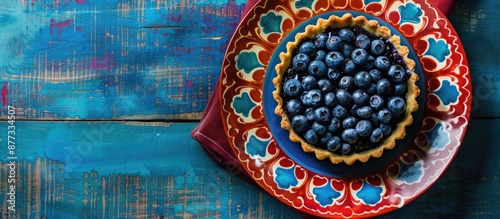 Overhead shot of a blueberry tart on a colorful plate with plenty of copy space image